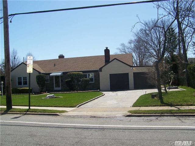 435 West Merrick Road Freeport, NY 11520 - Photo 1 of 1 a front view of a house with a garden and garage