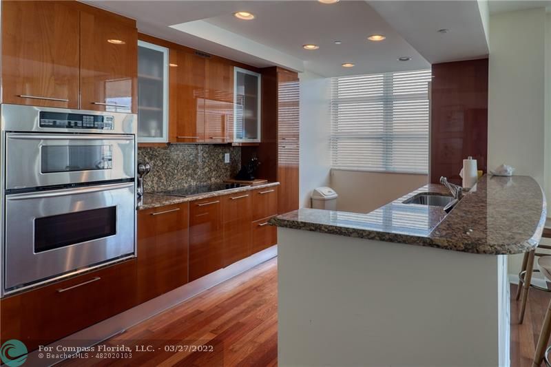 a kitchen with stainless steel appliances granite countertop a sink a stove and a microwave oven