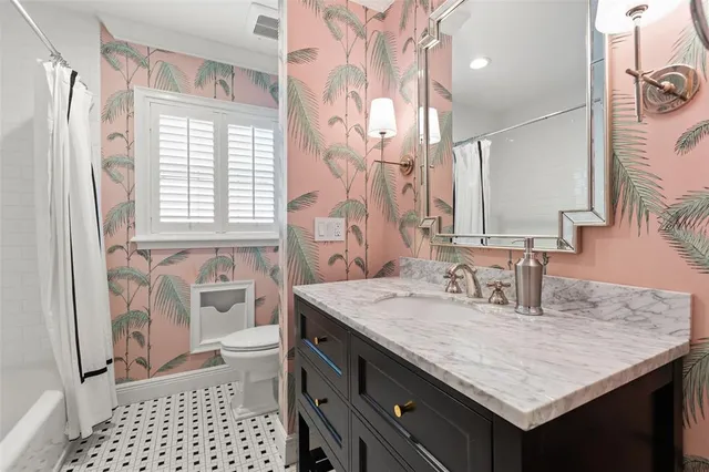 a bathroom with a granite countertop sink a toilet a shower and a mirror