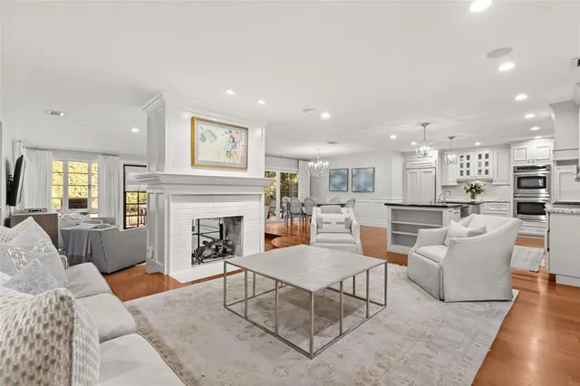 a living room with furniture a fireplace and kitchen view