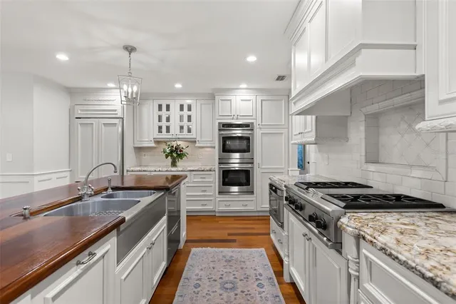 a kitchen with stainless steel appliances granite countertop a sink stove and cabinets