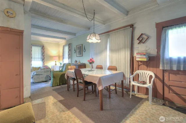 a dining room with wooden floor a chandelier a wooden table and chairs