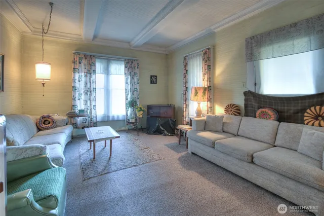 a living room with furniture and large windows