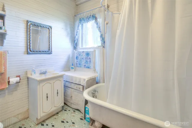 a bath tub sitting next to a white toilet and curtain