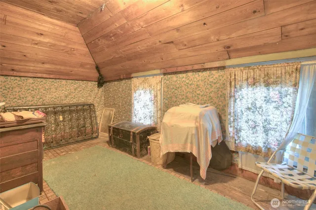 a bedroom with a bed and large windows