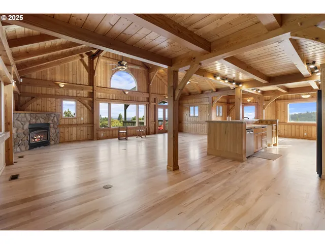 a view of an empty room with wooden floor and windows