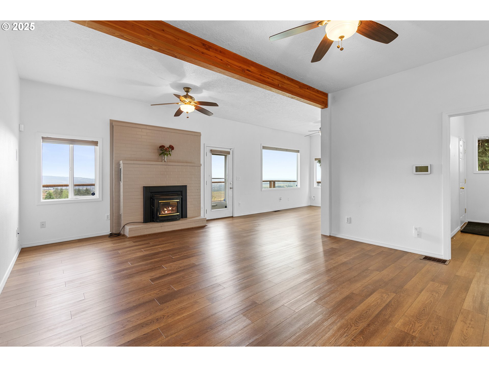 9325 Northeast Worden Hill Road Dundee, OR 97115 - Photo 30 of 48 an empty room with wooden floor fireplace and windows