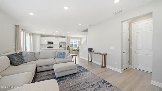 a living room with furniture and view of kitchen