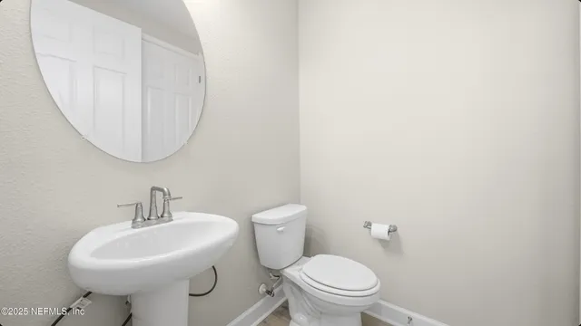a bathroom with a sink a toilet and mirror