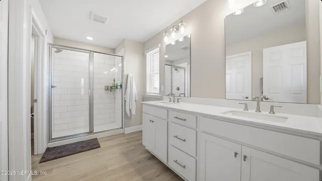 a spacious bathroom with double sink and shower