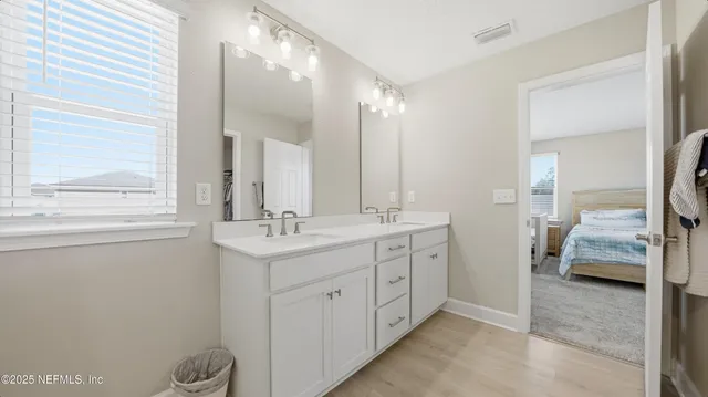 a en suite bathroom with a double vanity sink and a mirror