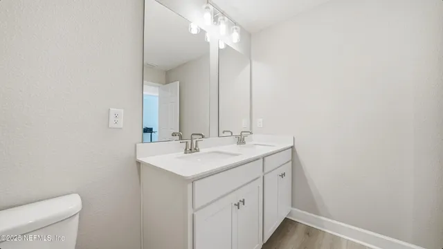 a bathroom with a sink a toilet and a mirror