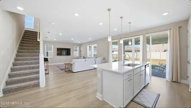 a kitchen with kitchen island granite countertop a sink and a stove top oven