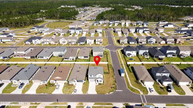 a view of a white house with a yard and table and chairs under an umbrella