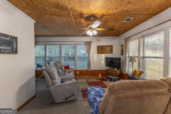 a living room with furniture tv and a large window
