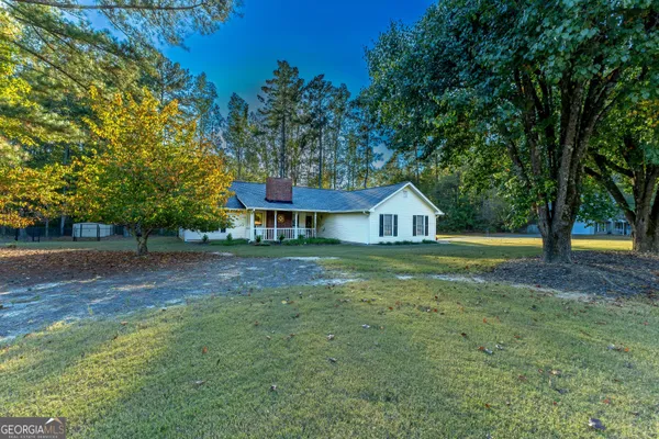 a front view of a house with a yard and trees