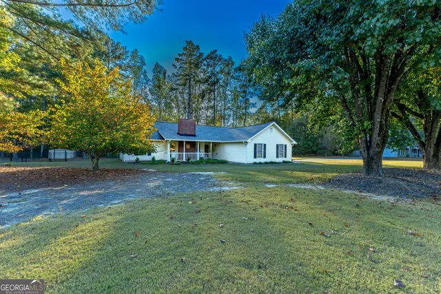 a front view of a house with a yard and trees