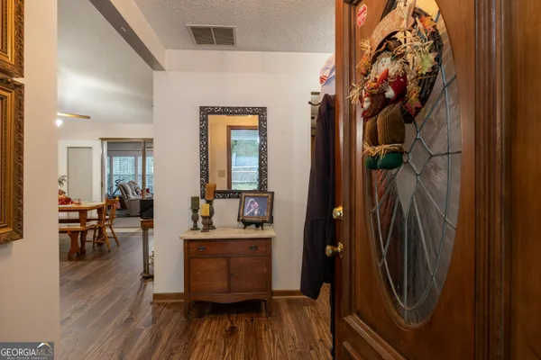 a view of a hallway and dining room with wooden floor