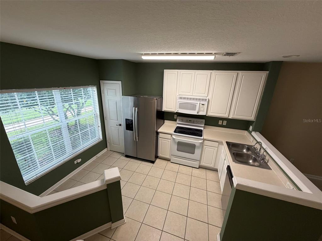 809 Shropshire Loop Sanford, FL 32771 - Photo 20 of 21 a kitchen with white cabinets a stove top oven and sink