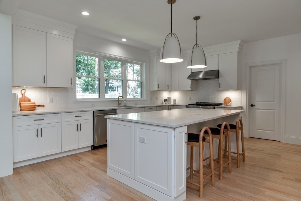 33 Birch Road Natick, MA 01760 - Photo 13 of 35 a kitchen with stainless steel appliances granite countertop a sink a stove and a wooden floor