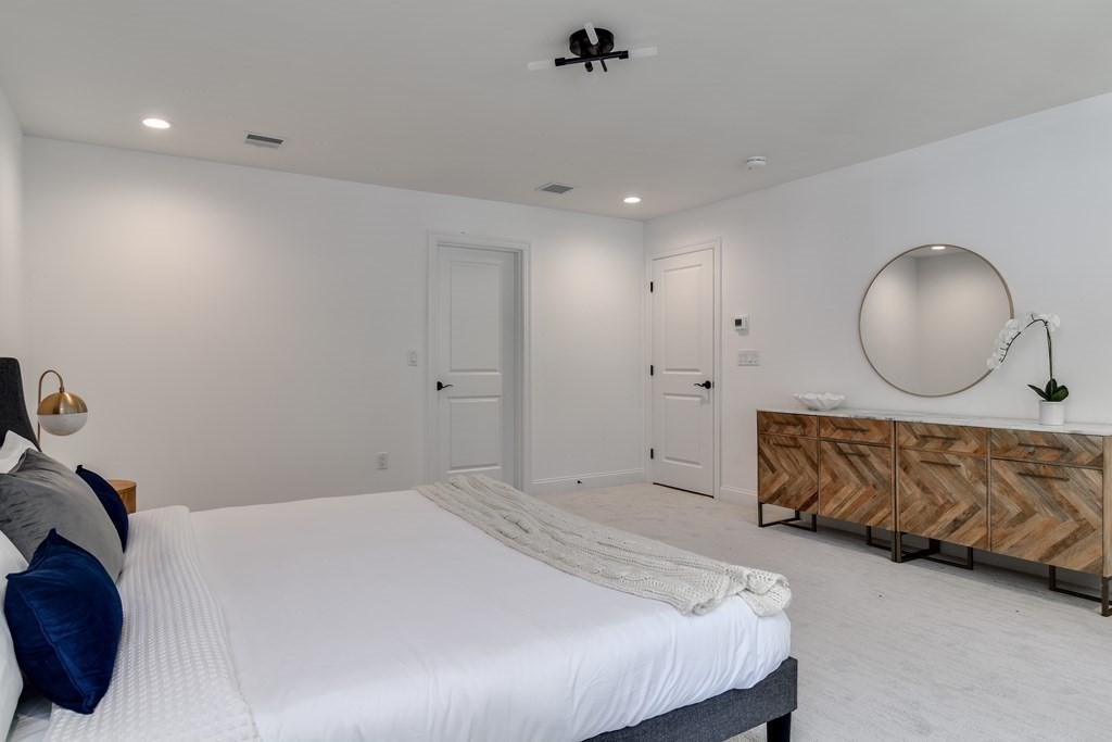33 Birch Road Natick, MA 01760 - Photo 20 of 35 a bed room with a bed mirror and a chandelier