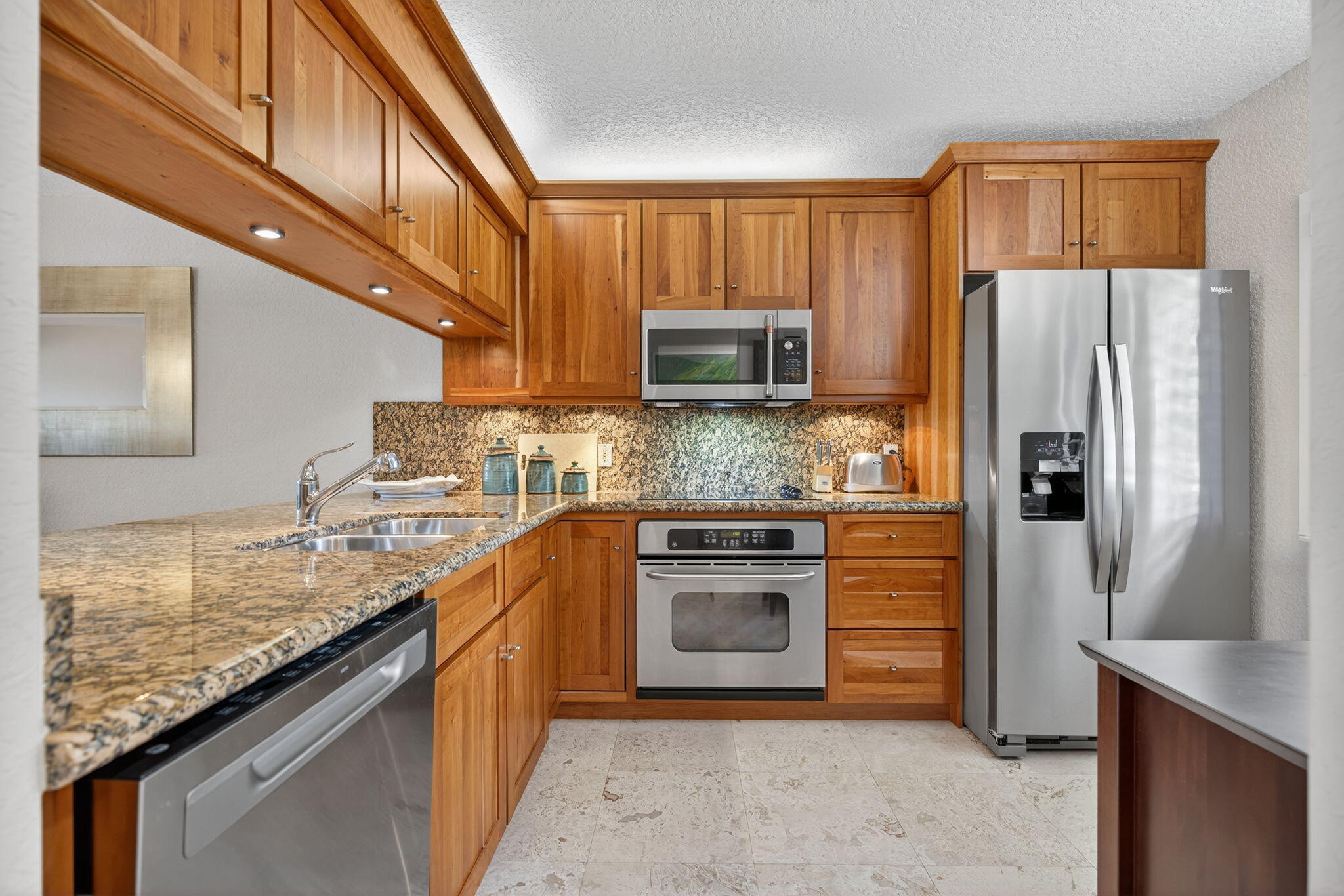 401 Ocean Bluffs Boulevard, Unit 205 Jupiter, FL 33477 - Photo 4 of 42 a kitchen with stainless steel appliances granite countertop a refrigerator stove microwave and sink