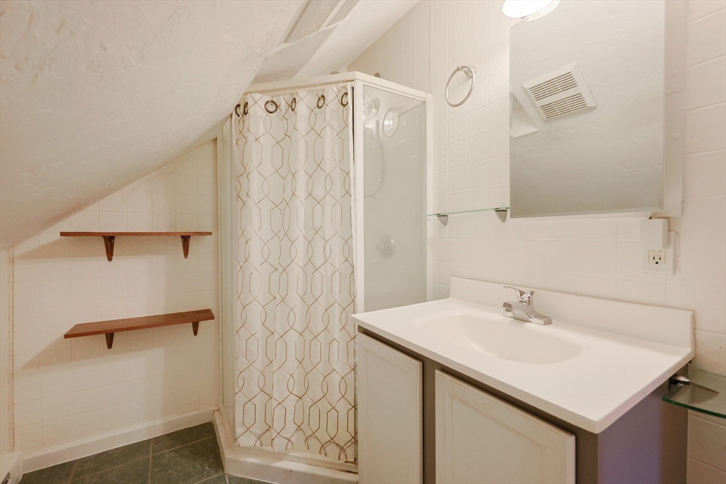 107 Lake Street, Unit B Webster, MA 01570 - Photo 28 of 42 a bathroom with a sink a mirror and shower curtain