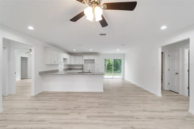 a view of kitchen with kitchen island stainless steel appliances wooden floor and window