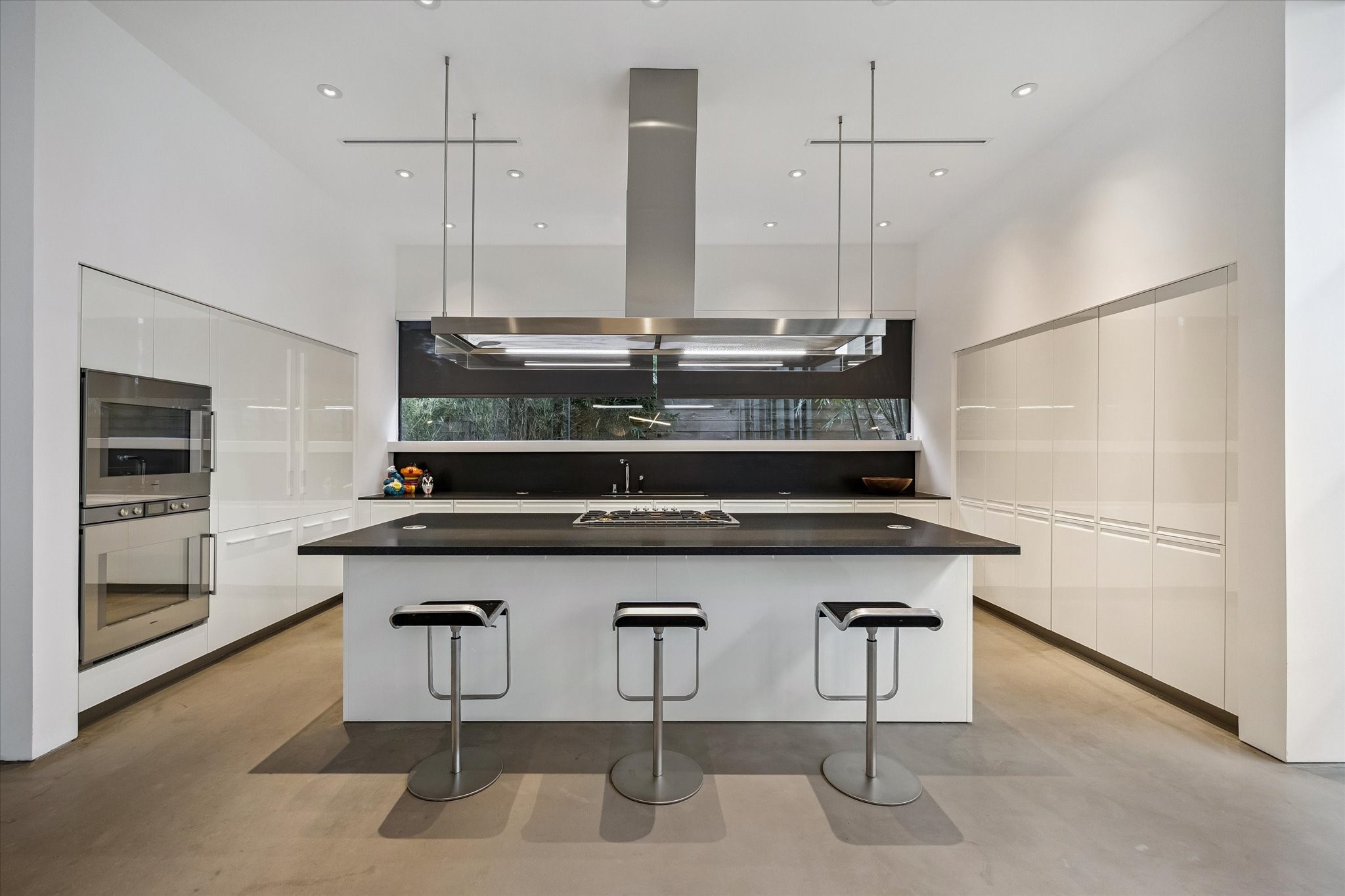 1527 Indiana Street Houston, TX 77006 - Photo 11 of 30 The stunning kitchen features premium Gaggenau appliances, an oversized island with seating, integrated storage, and a statement suspended linear vent hood.