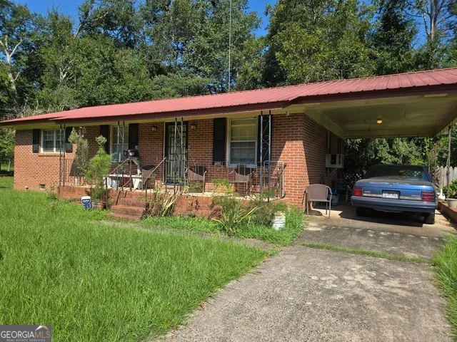 a view of a patio with table and chairs under an umbrella