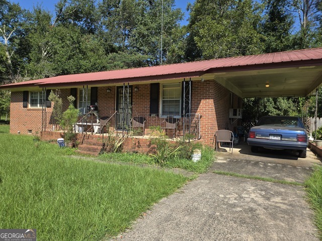 a view of a patio with table and chairs under an umbrella