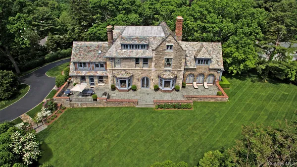 an aerial view of residential houses with outdoor space and trees
