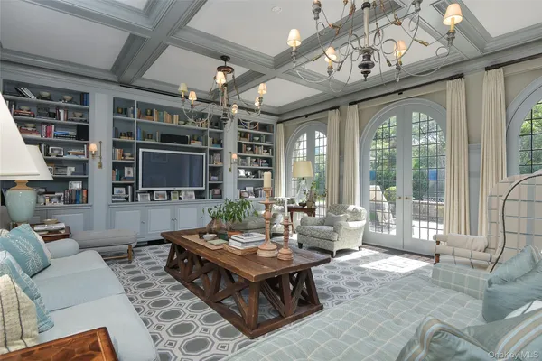 a living room with furniture a flat screen tv and a large window