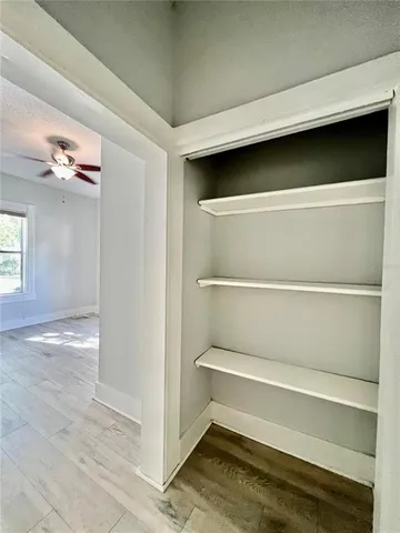 a view of walk in closet with empty racks
