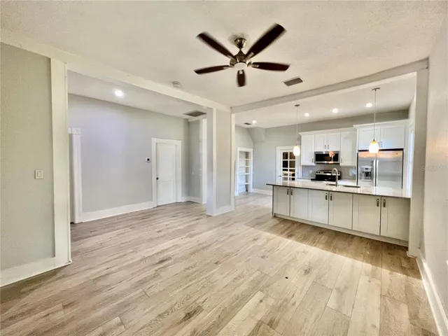 a view of kitchen with granite countertop cabinets and refrigerator