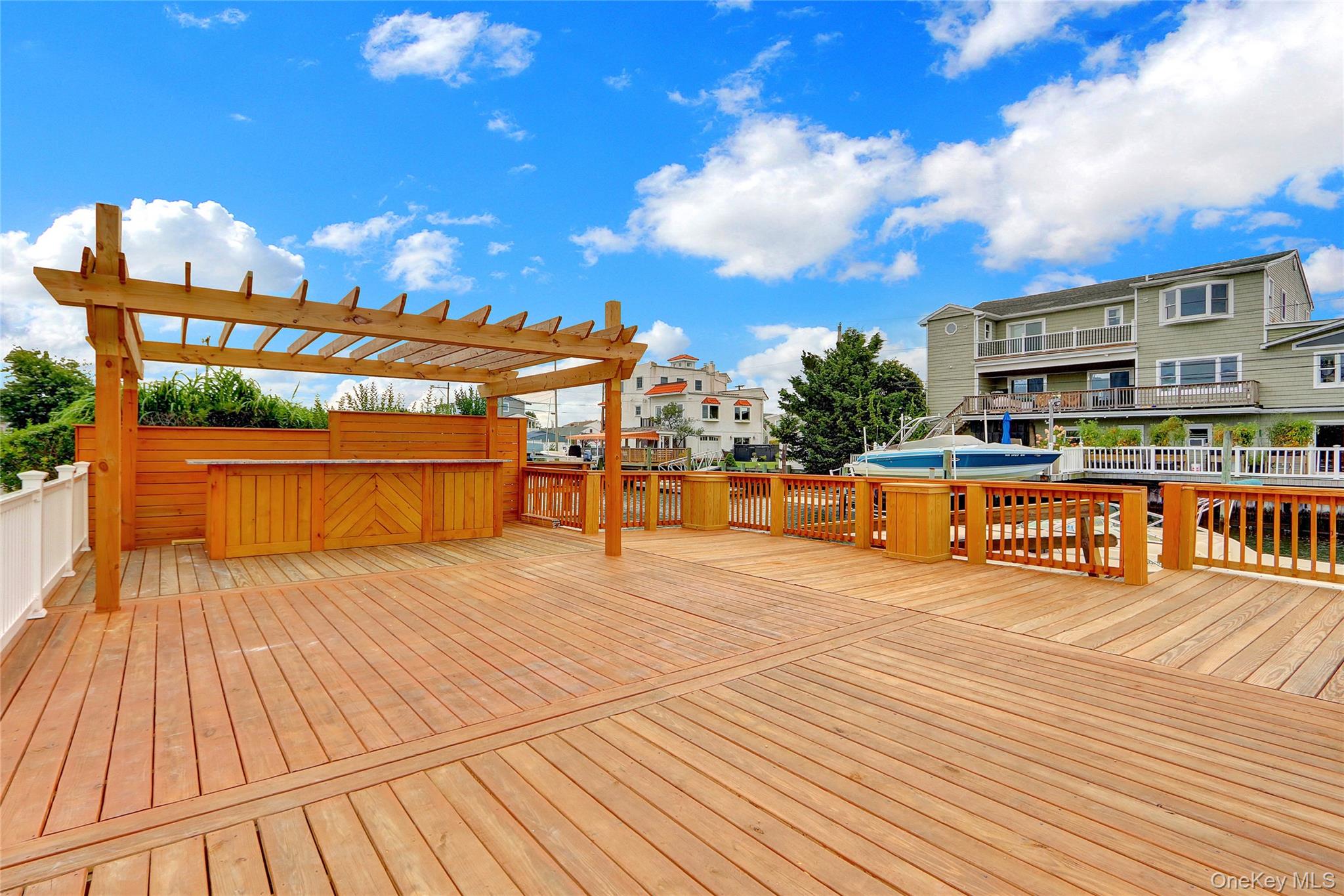 Deck featuring a hot tub, a residential view, and a pergola