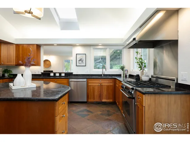 a kitchen with kitchen island granite countertop a sink cabinets and window