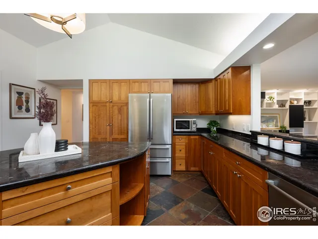 a kitchen with stainless steel appliances granite countertop a sink refrigerator and cabinets