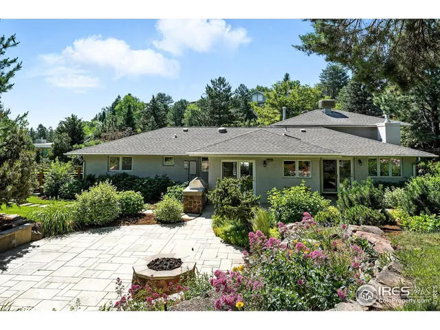 a view of a white house with a yard and potted plants