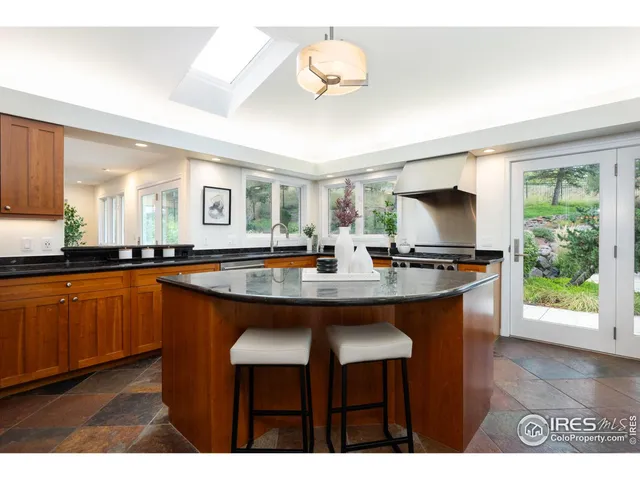 a kitchen with stainless steel appliances granite countertop a sink and a refrigerator