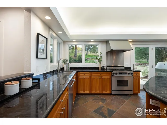a kitchen with stainless steel appliances granite countertop a stove a sink and a refrigerator