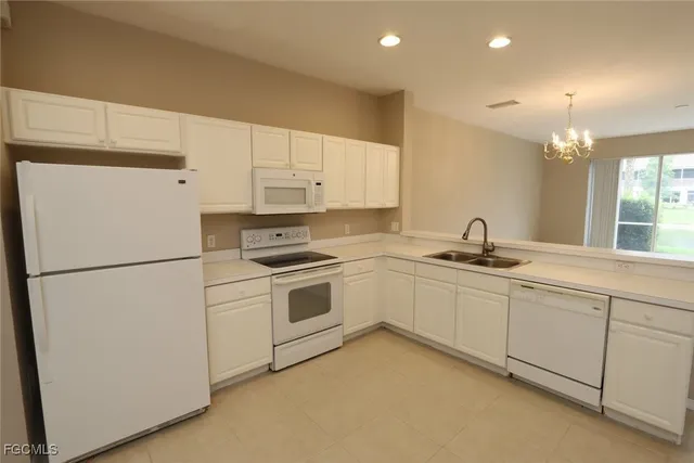 a kitchen with appliances a sink and cabinets