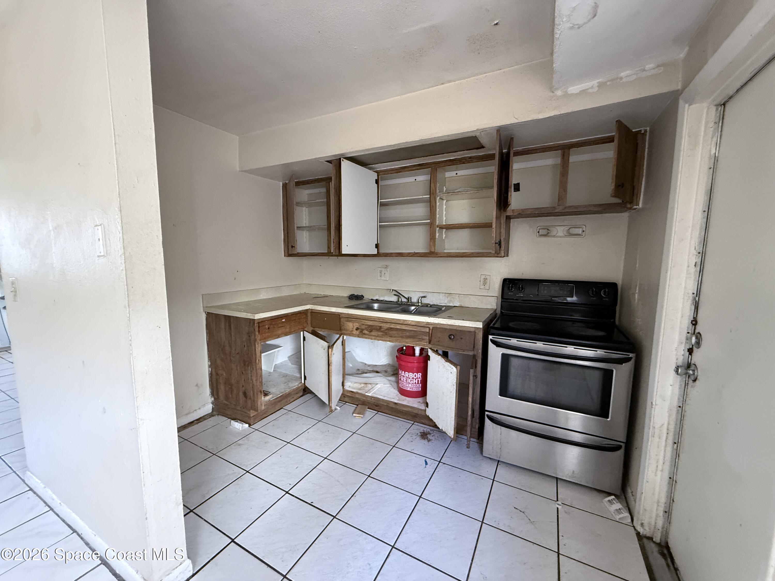 27 Ella Street, Unit B Melbourne, FL 32935 - Photo 9 of 18 a kitchen with granite countertop a stove and a refrigerator