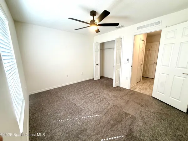 a view of a livingroom with a ceiling fan and window