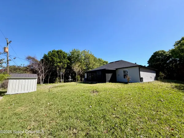 a large house with a yard and large trees