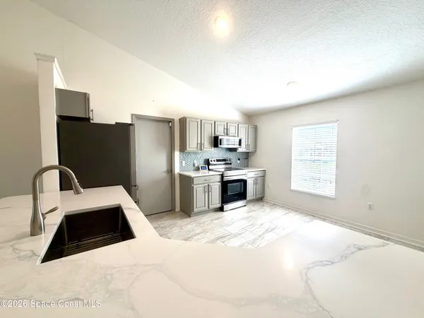 a kitchen with stainless steel appliances a stove a refrigerator and a sink