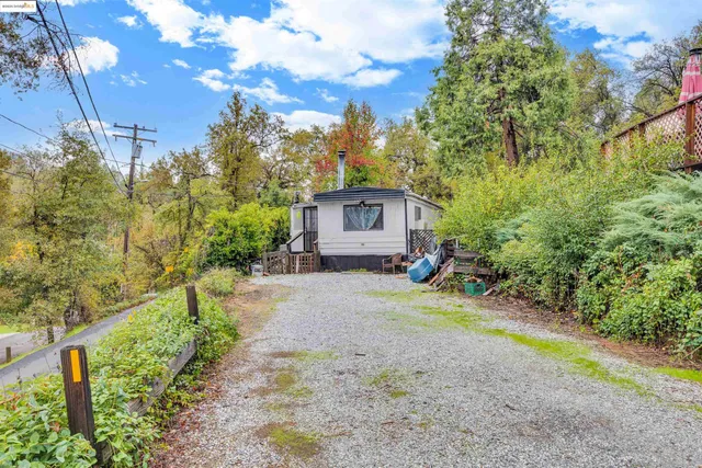 a view of house with outdoor space and trees in the background