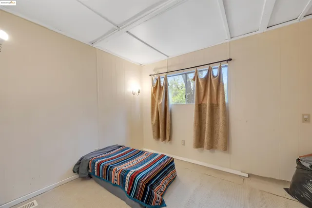 a bedroom with a bed dresser and a window