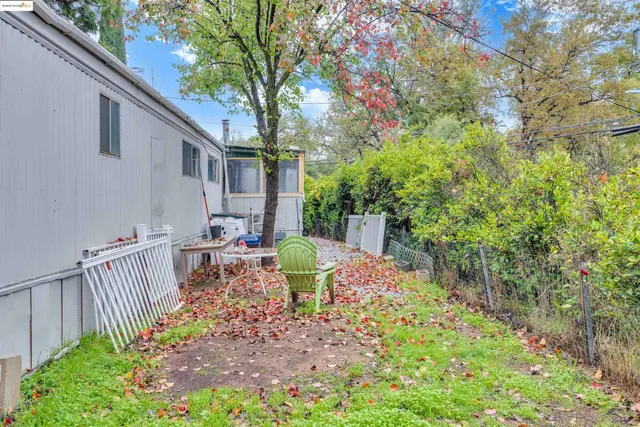 a view of a chair and table in backyard of the house
