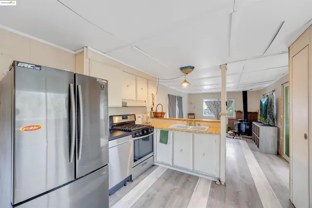 a kitchen with stainless steel appliances granite countertop a refrigerator and a stove top oven